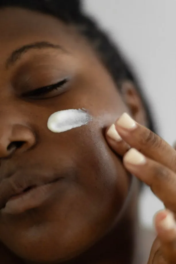 Mujer aplicándose crema en el rostro